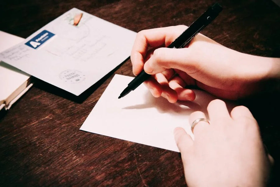 A hand writing a message on a card