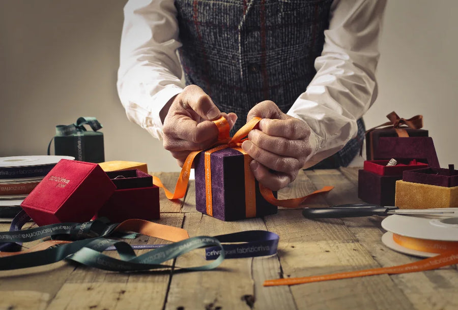 Hands tying a ribbon around a wrapped gift