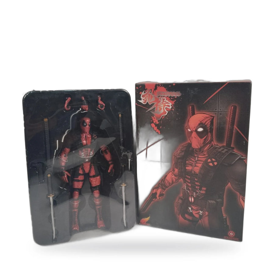 Deadpool action figure in its moulded tray with twin swords and spare hands, beside the box