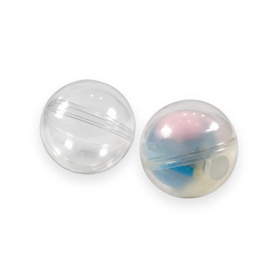Pastel pink, blue and yellow swirl squishy ball next to its open clear round capsule